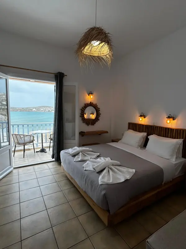 Une chambre lumineuse avec un grand lit et une vue sur la mer.