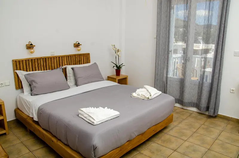 Une chambre lumineuse avec un grand lit et une décoration sobre.