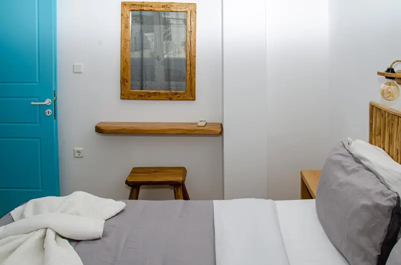 Une chambre lumineuse avec un lit et un miroir mural.