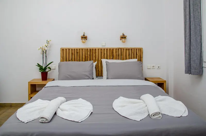 Une chambre lumineuse avec un grand lit et une décoration murale en bois.