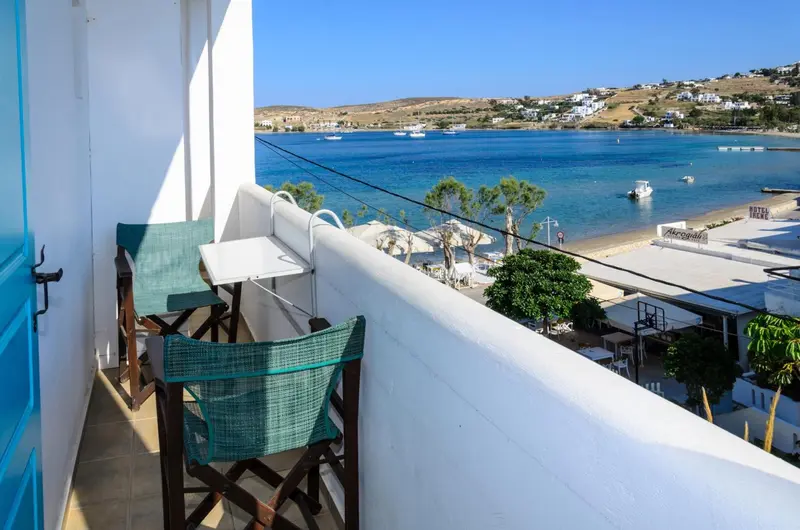 Balcon avec mobilier d'extérieur donnant sur une plage et la mer.