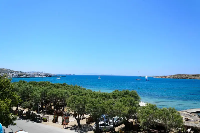 Vue sur une baie turquoise avec des voiliers et une végétation luxuriante.