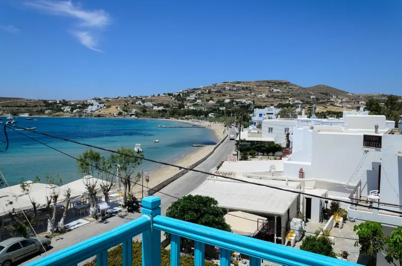Vue sur une baie avec une plage et des bâtiments blancs.