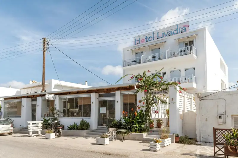 Façade d'un bâtiment blanc à deux étages avec des balcons et une végétation.