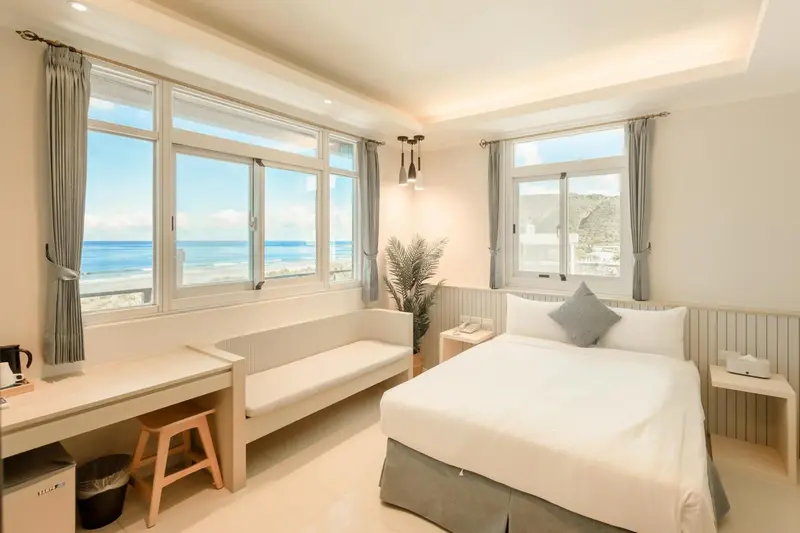 Chambre lumineuse avec vue sur la mer et un espace détente.