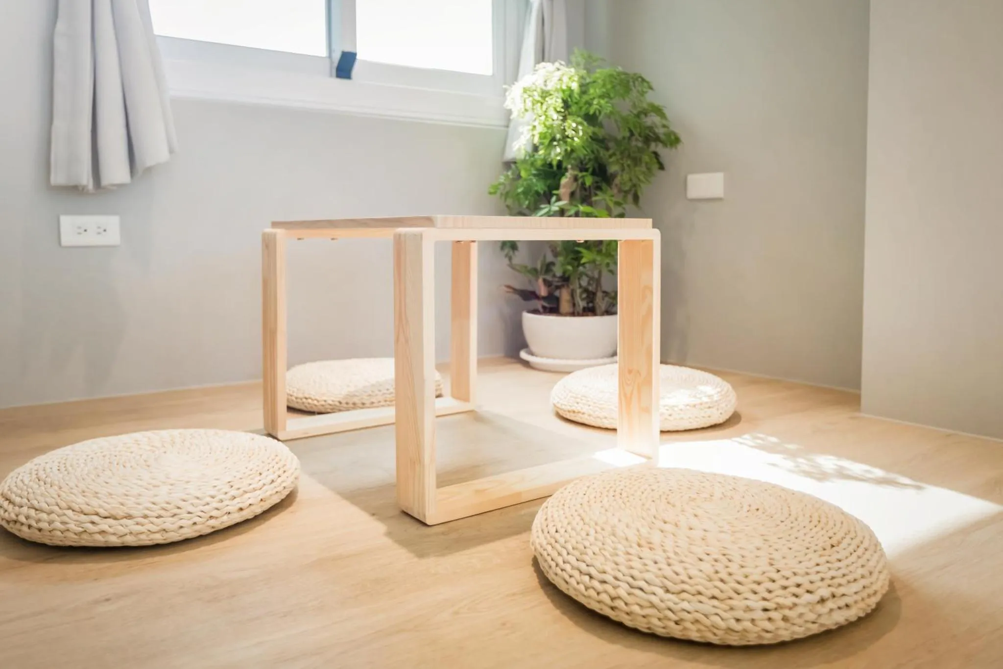 Espace de détente avec assises au sol et table basse en bois.