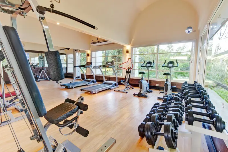 Une salle de sport lumineuse avec des équipements de musculation et des machines cardio.