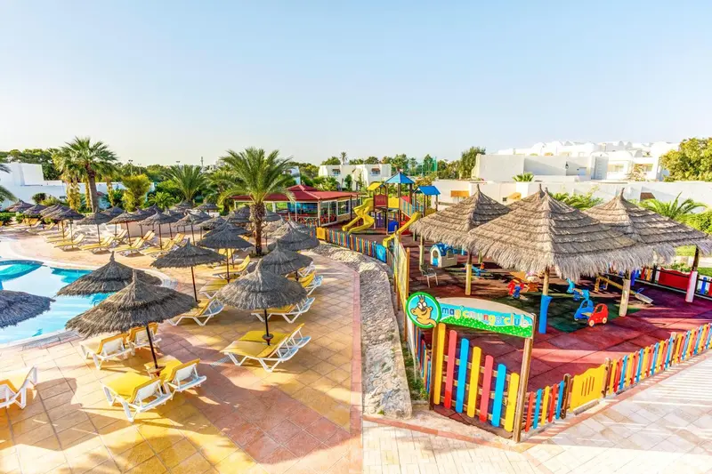 Vue aérienne d'un espace de jeux pour enfants avec parasols et transats.