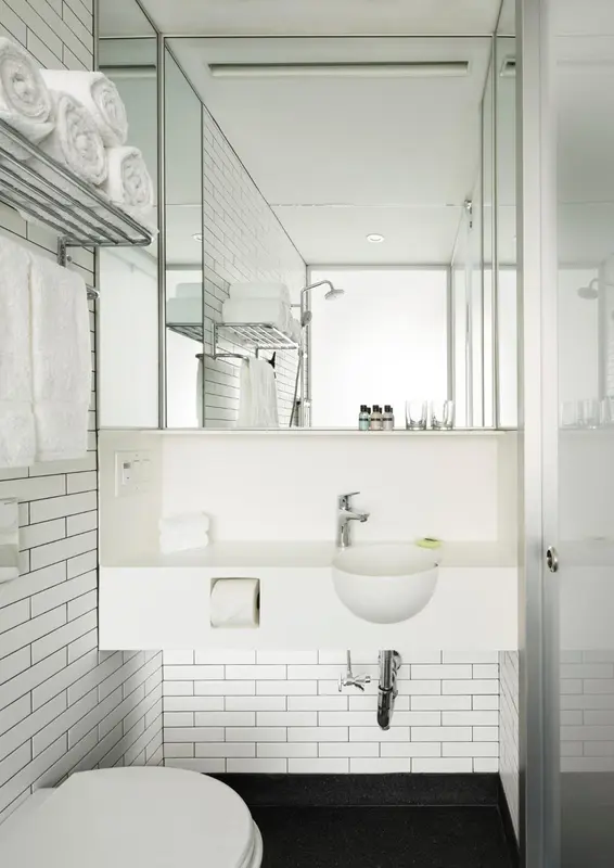 Une salle de bain moderne avec carrelage blanc et équipements sanitaires.