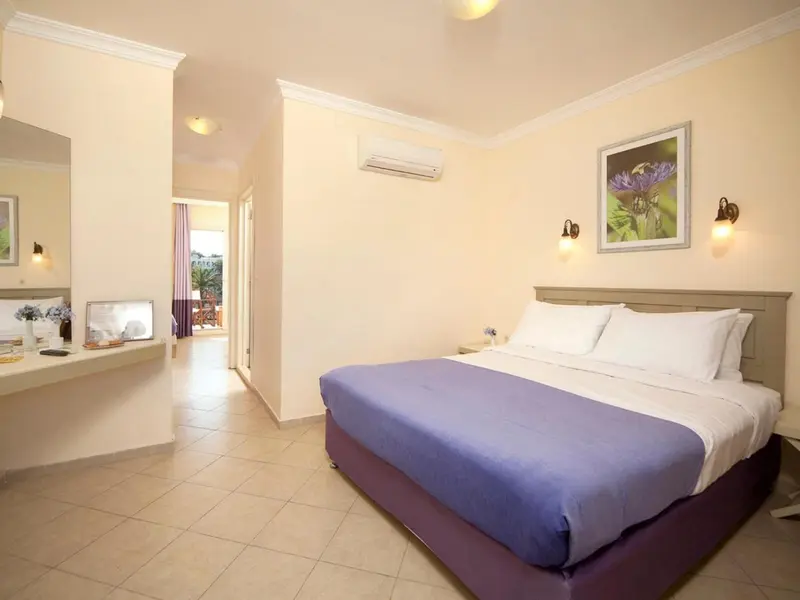 Une chambre lumineuse avec un grand lit et un accès à une terrasse.