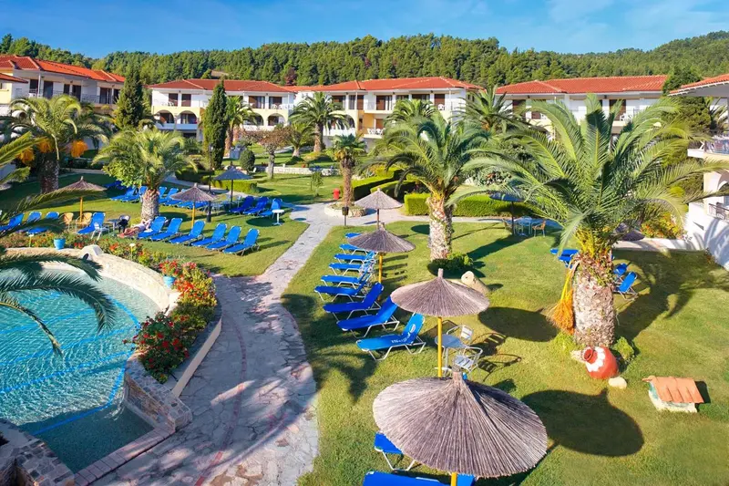 Vue aérienne d'un complexe hôtelier avec piscine et pelouse verdoyante.