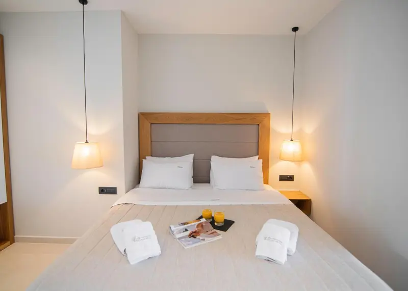 Une chambre lumineuse avec un grand lit et des lampes suspendues.