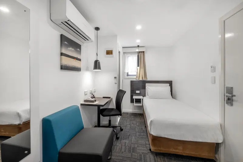 Une chambre simple avec un lit, un bureau et un canapé.