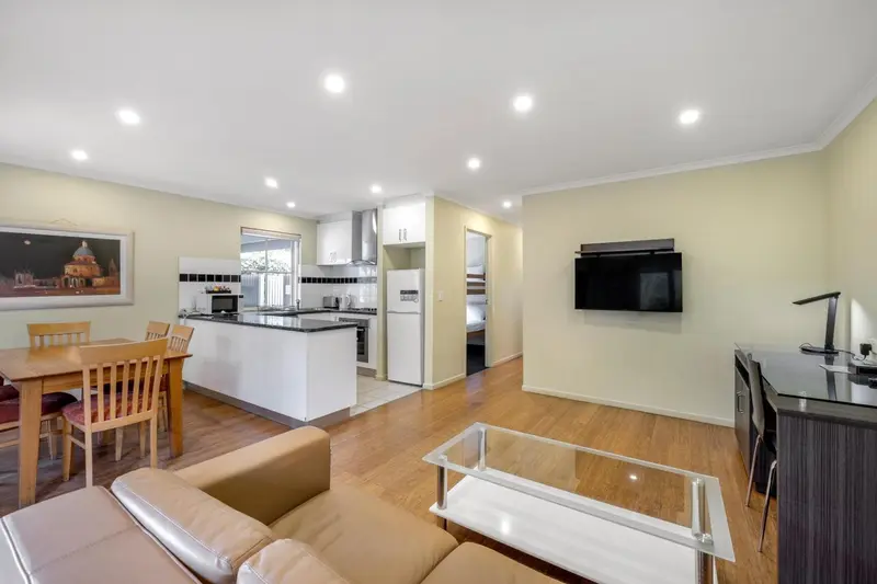 Espace de vie lumineux avec coin repas et cuisine ouverte.