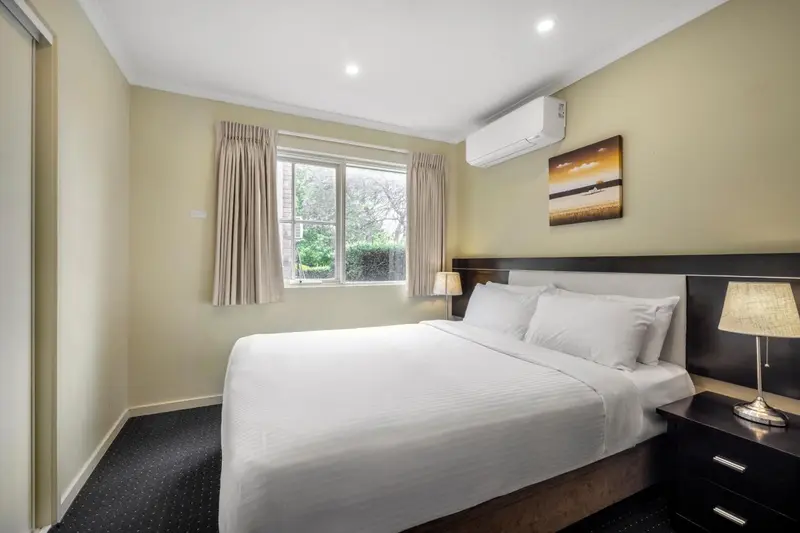 Une chambre lumineuse avec un grand lit et une décoration sobre.