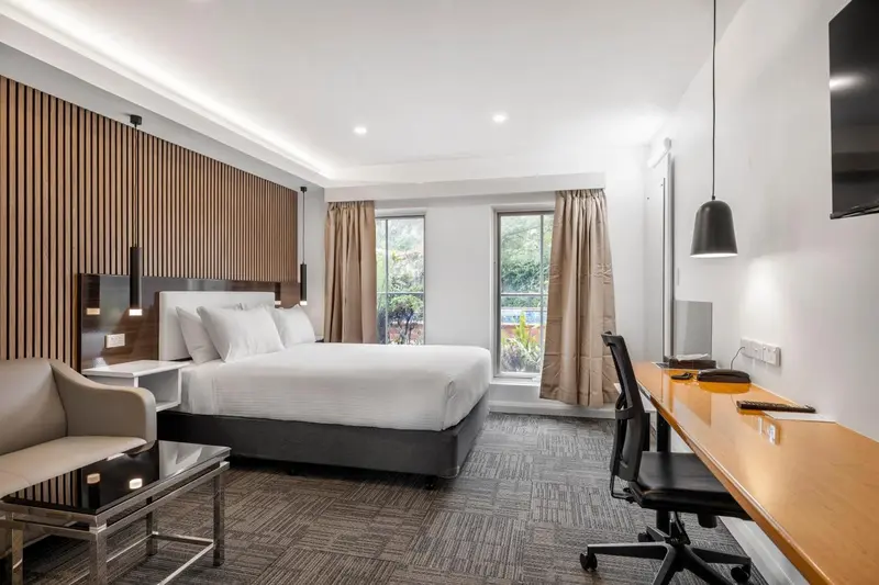 Une chambre d'hôtel lumineuse avec un grand lit et un espace de travail.