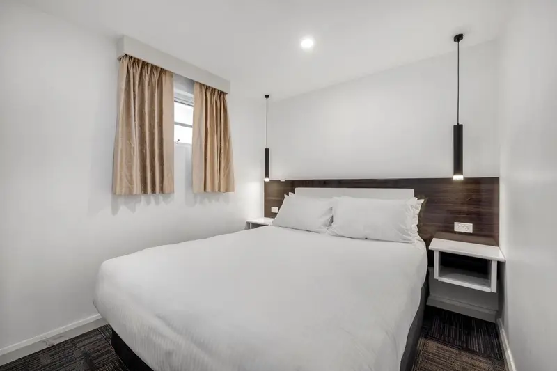 Une chambre lumineuse avec un grand lit recouvert de draps blancs.
