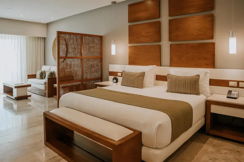 Une chambre lumineuse avec un grand lit et un coin salon.
