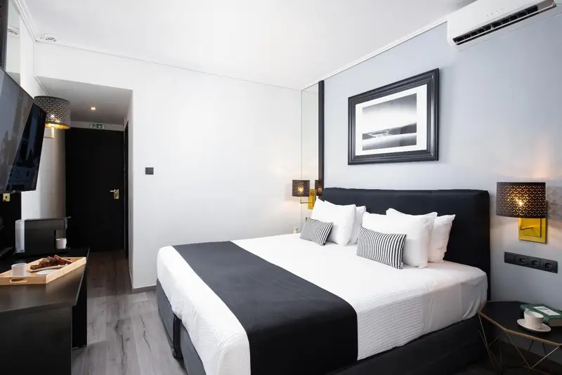 Une chambre moderne avec un grand lit recouvert d'une couette blanche et noire.