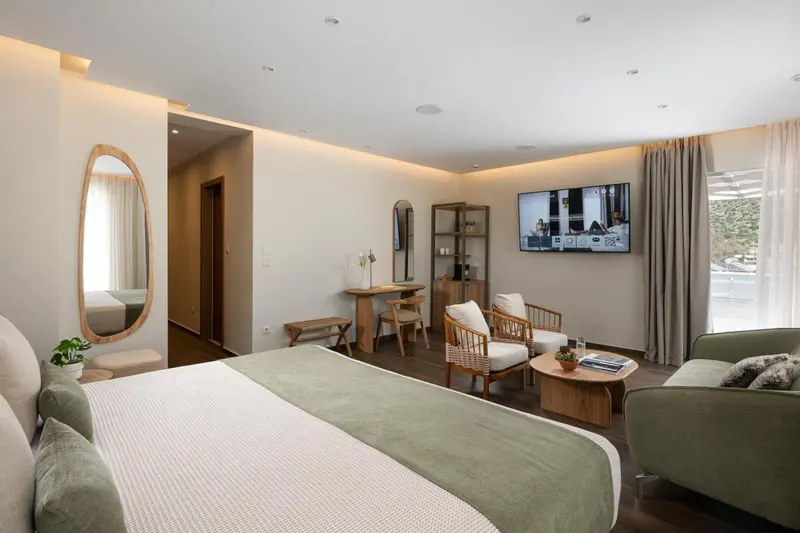 Une chambre lumineuse avec un grand lit et un espace salon.