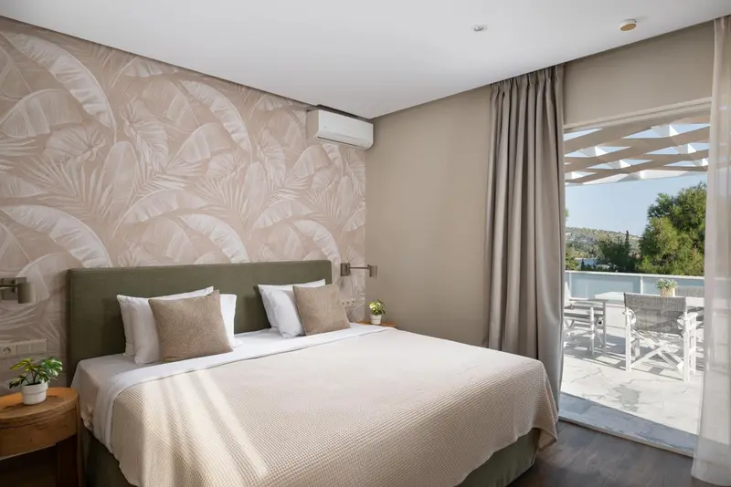 Une chambre lumineuse avec un grand lit et un accès à une terrasse.