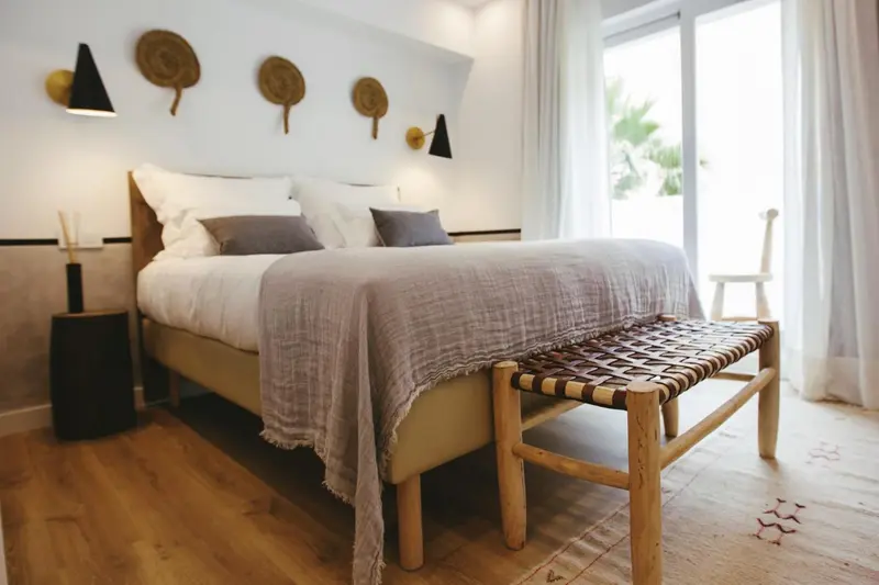 Une chambre lumineuse avec un grand lit et une décoration murale.