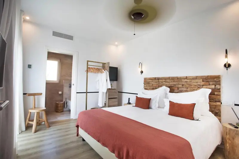 Une chambre lumineuse avec un grand lit et un accès à une salle de bain.