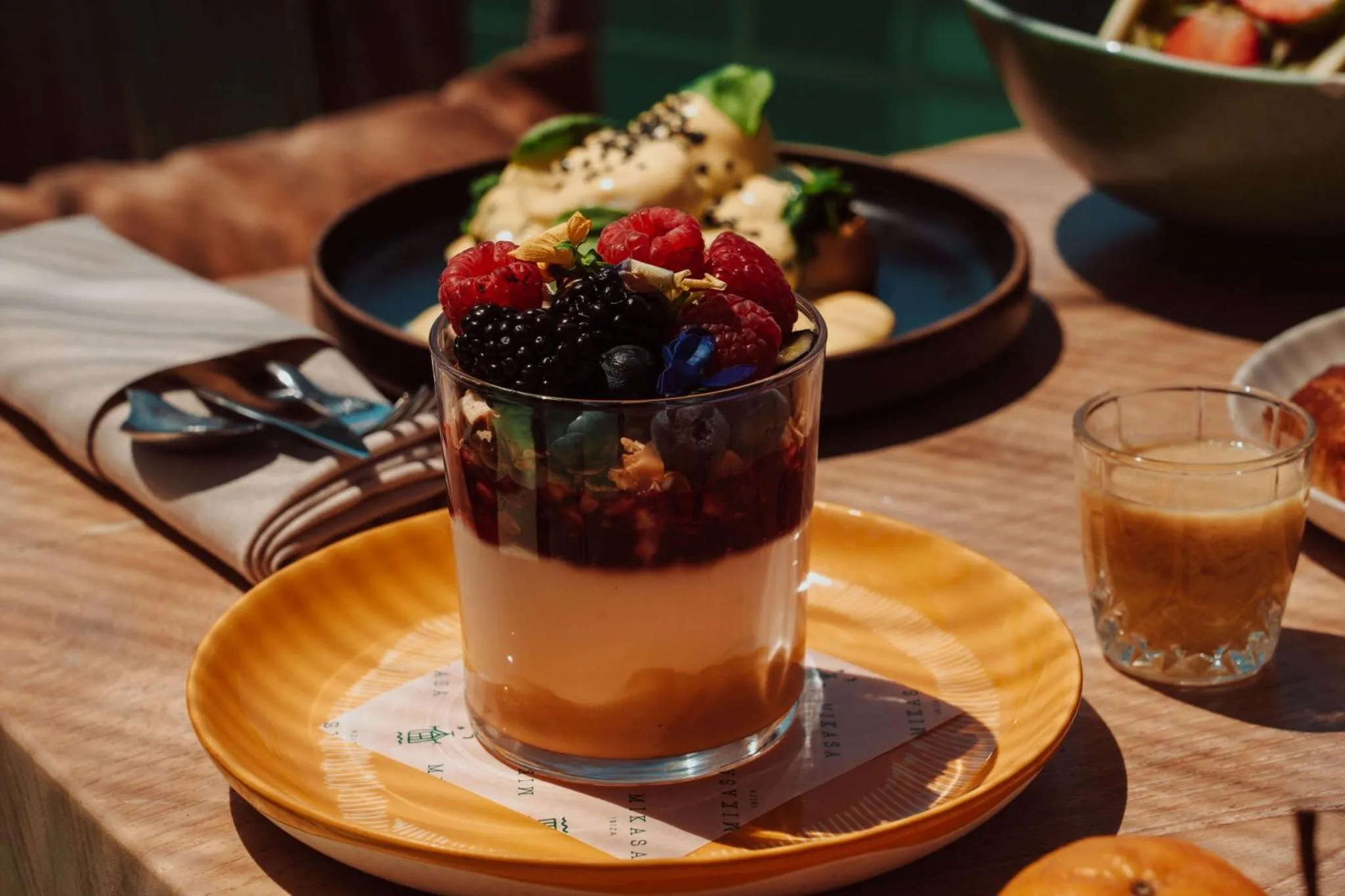 Assiettes de fruits frais et de yaourt sur une table en bois.