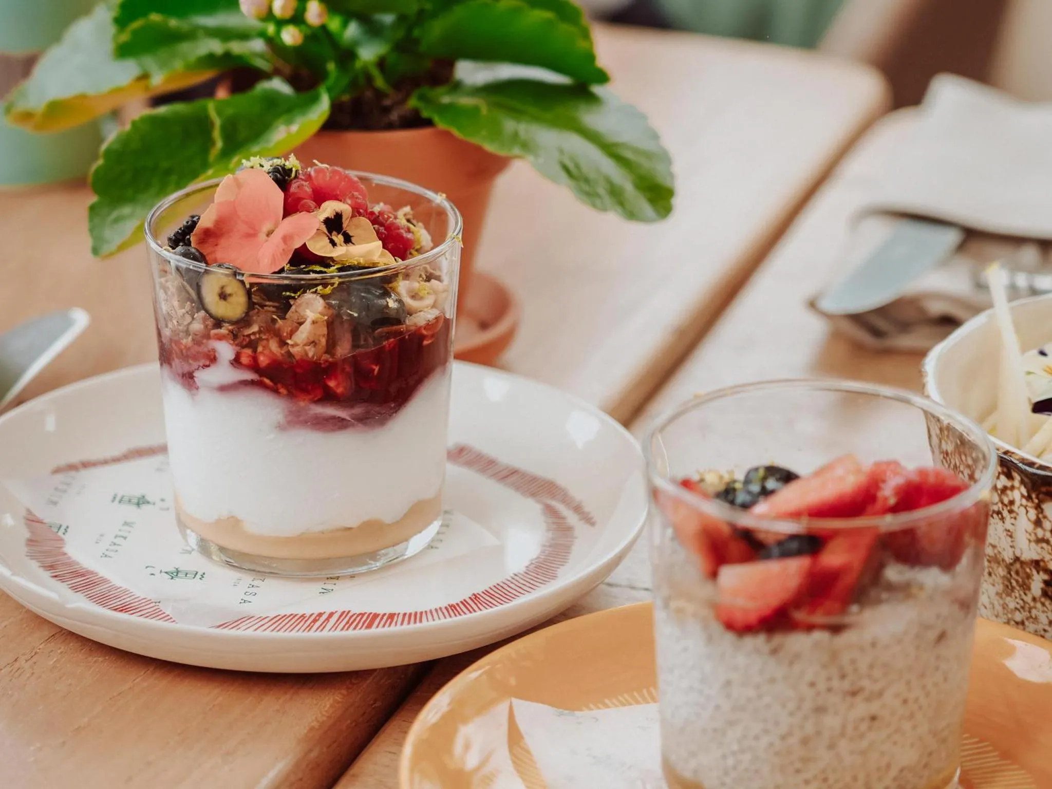 Un dessert fruité est présenté dans un verre sur une table.