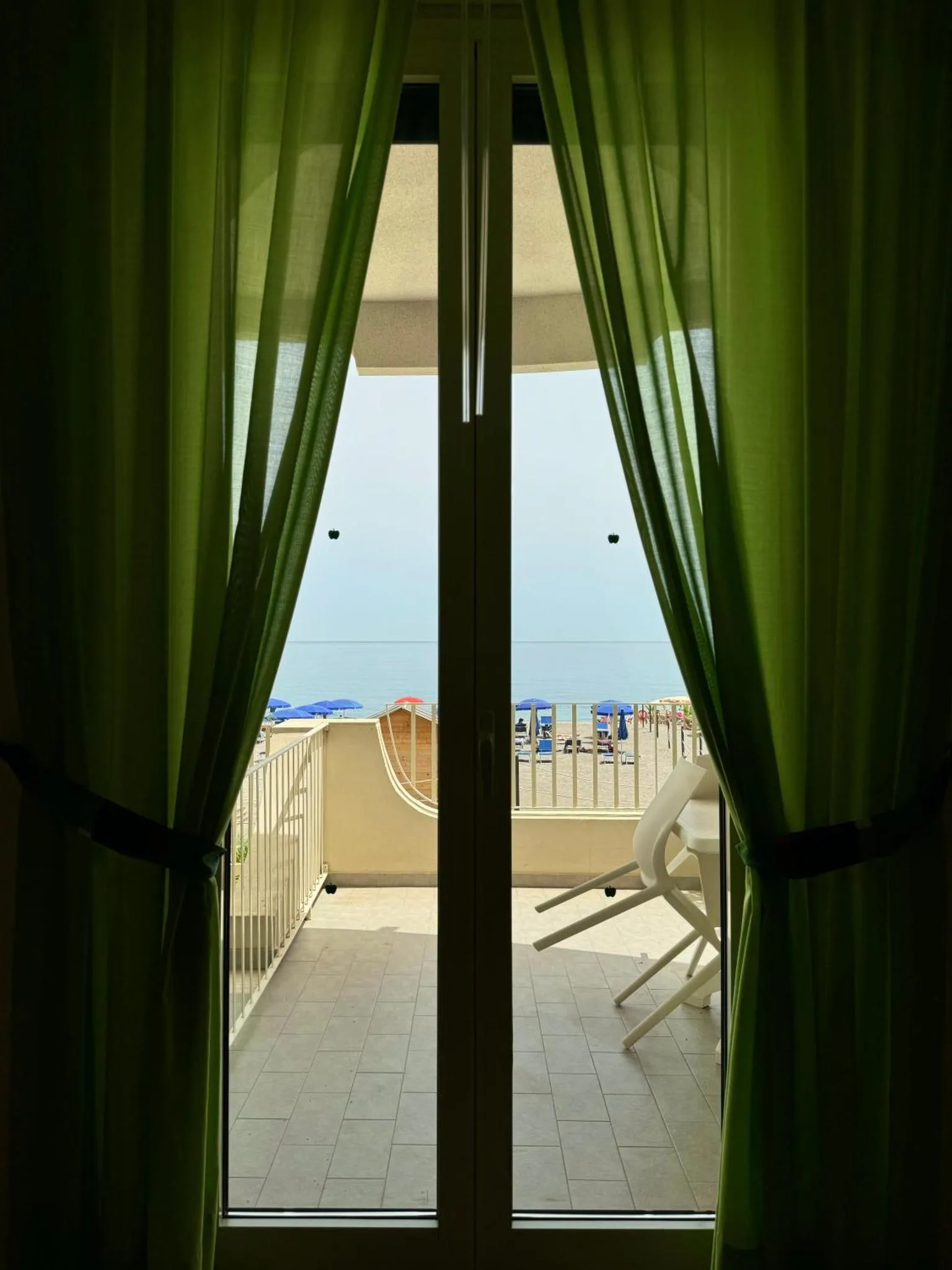 Vue sur la mer depuis une terrasse ombragée.