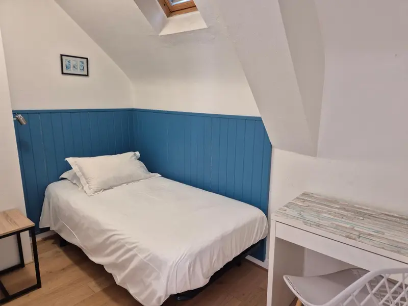 Une chambre simple avec un lit et un bureau.