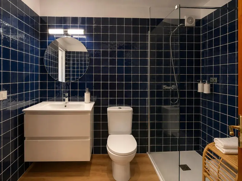 Une salle de bain moderne avec des carreaux bleus et une douche à l'italienne.