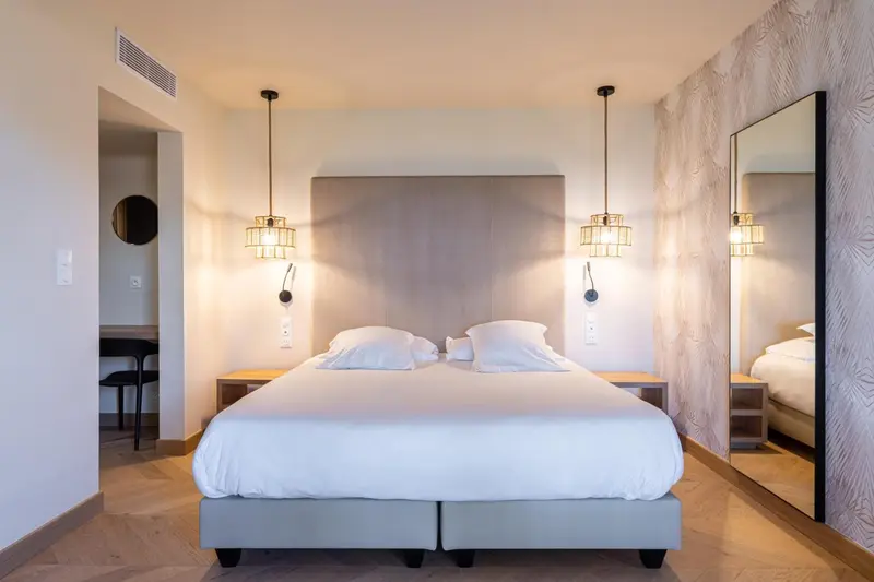 Une chambre moderne avec un grand lit et des lampes suspendues.