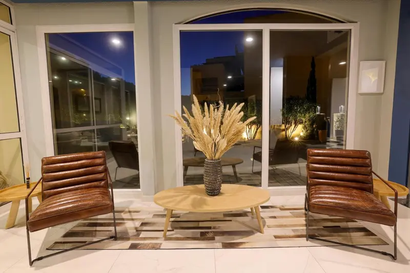 Espace de détente intérieur avec mobilier en cuir et décoration florale.