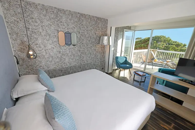 Une chambre lumineuse avec un grand lit et un accès à une terrasse.