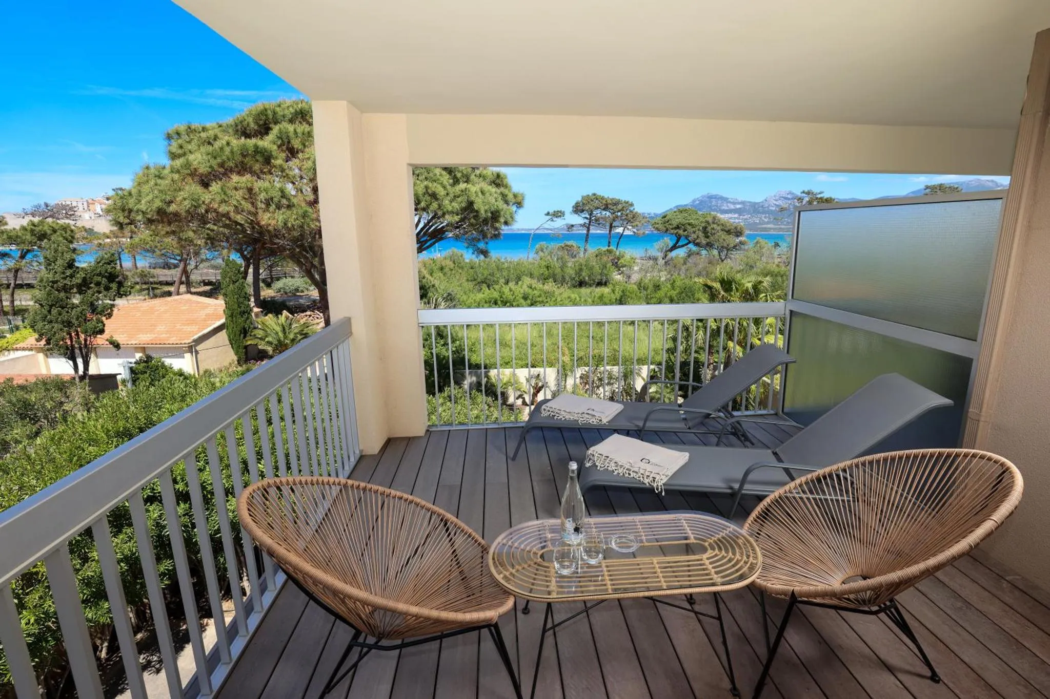 Terrasse aménagée avec mobilier de jardin et vue sur la mer.