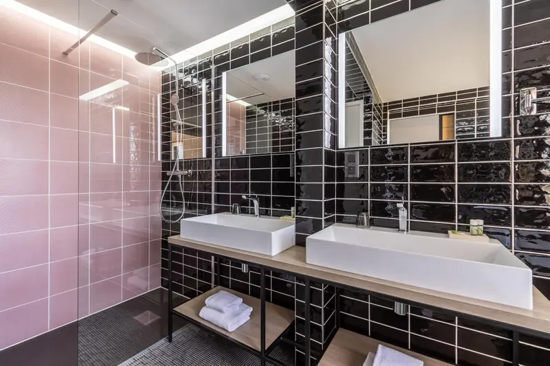 Salle de bain moderne avec deux vasques et douche à l'italienne.