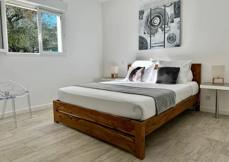 Une chambre lumineuse avec un grand lit et une décoration moderne.
