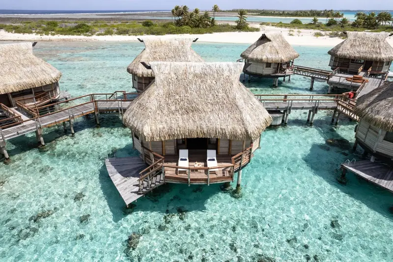 Des bungalows sur pilotis s'étendent sur une eau turquoise et peu profonde.