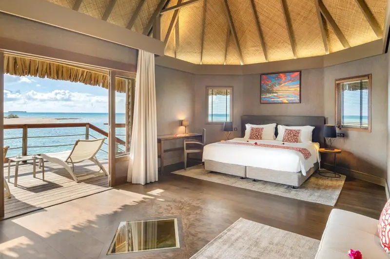Une chambre lumineuse s'ouvre sur une terrasse avec vue sur la mer.