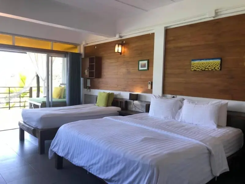 Une chambre lumineuse avec deux lits et une vue sur l'extérieur.