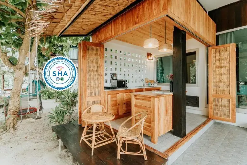 Une cuisine ouverte sur une terrasse en bois avec deux tabourets.