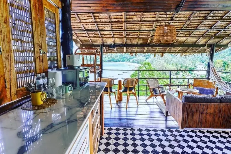 Une cuisine ouverte donne sur une terrasse avec salon et vue sur la mer.