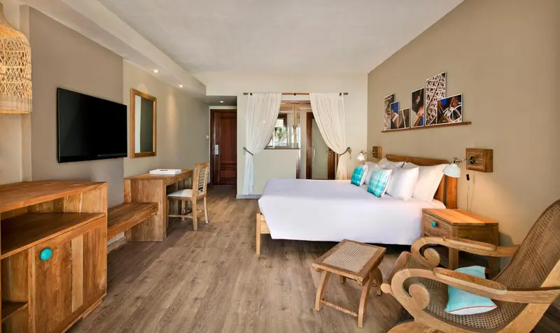 Une chambre lumineuse avec un grand lit et un coin salon.