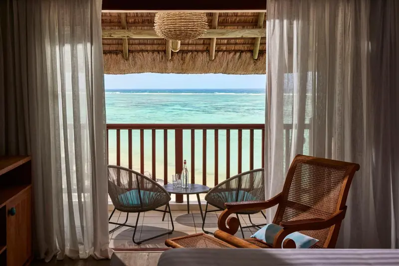 Vue sur l'océan depuis une terrasse aménagée avec des fauteuils.