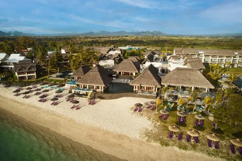 Vue aérienne d'un complexe hôtelier avec plage et parasols.