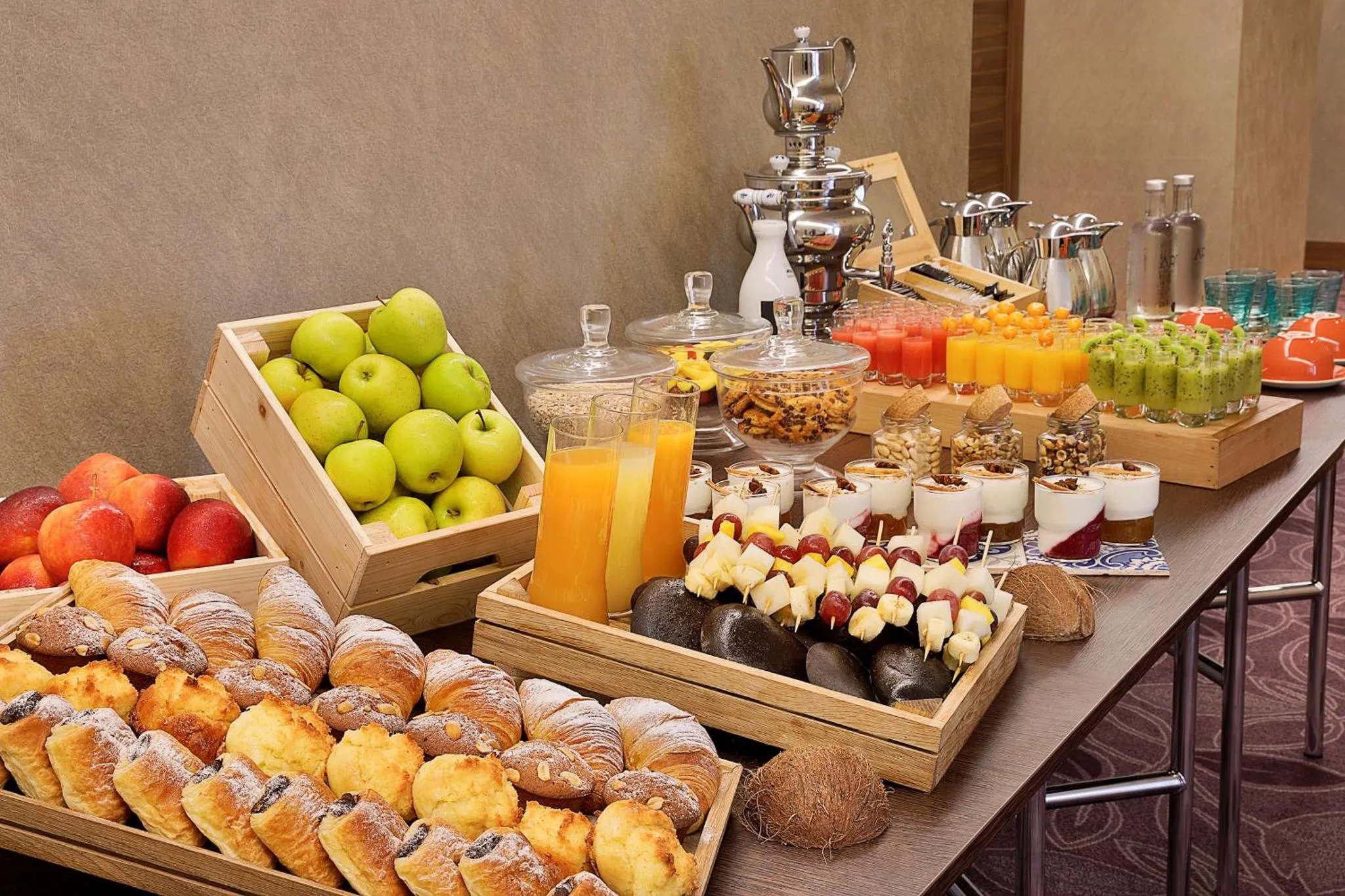 Un buffet propose des viennoiseries, des fruits frais et des jus.