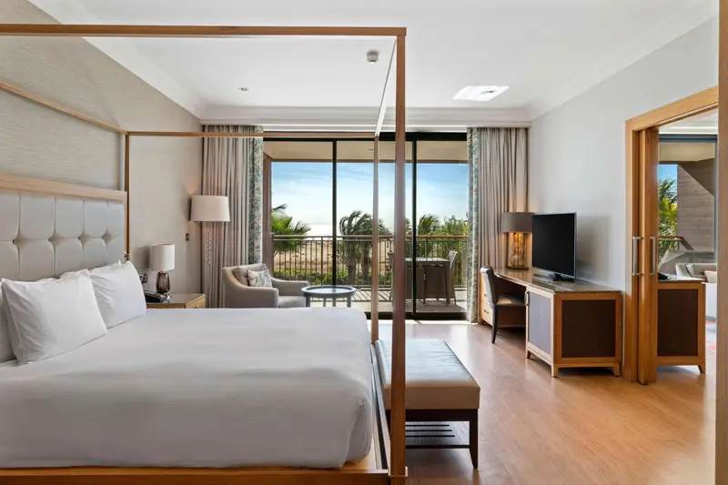 Une chambre lumineuse avec un grand lit et une vue sur la mer.