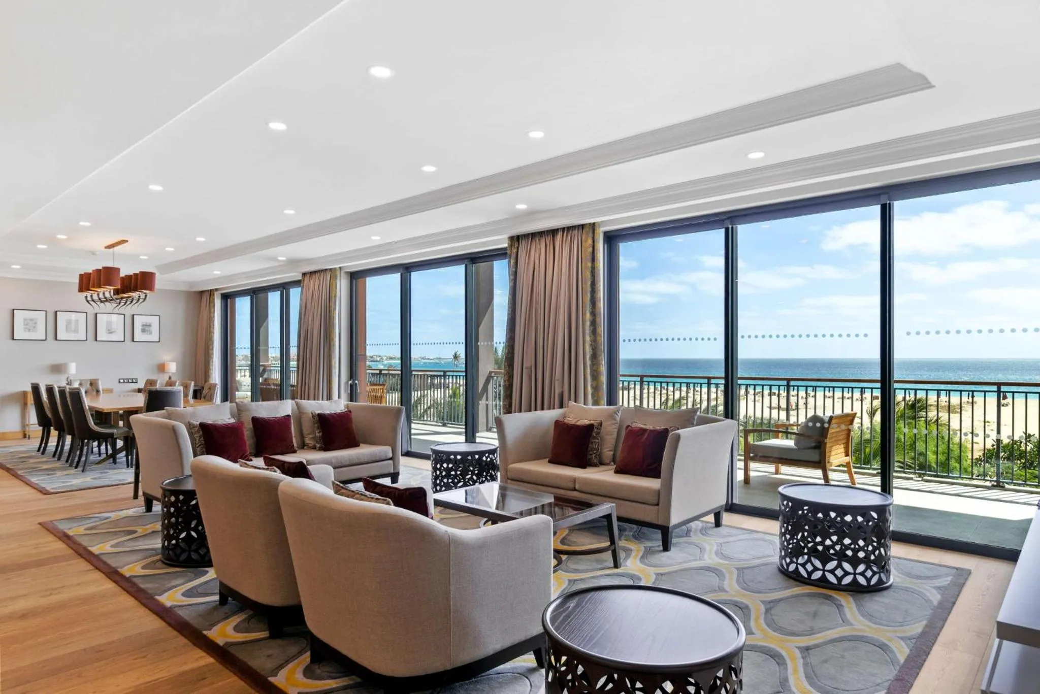 Espace de détente lumineux avec canapés et vue sur la mer.