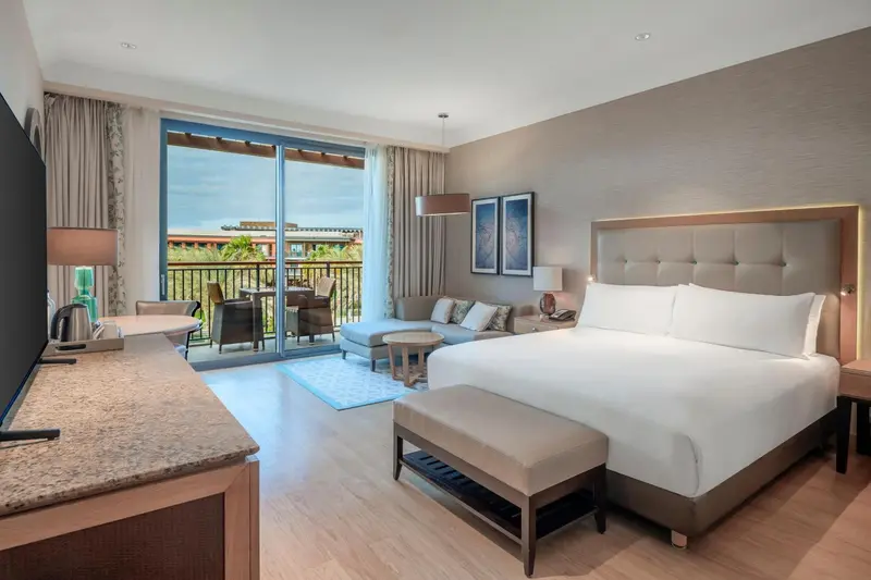 Une chambre lumineuse avec un grand lit et un accès à une terrasse.